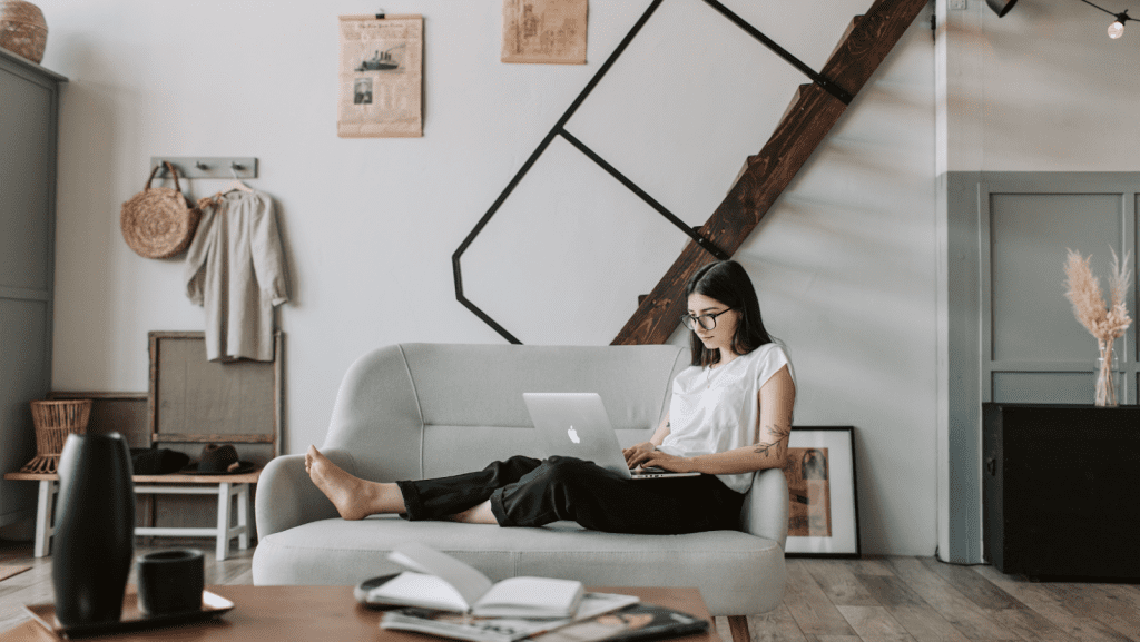 Woman sitting on the couch with a Macbook