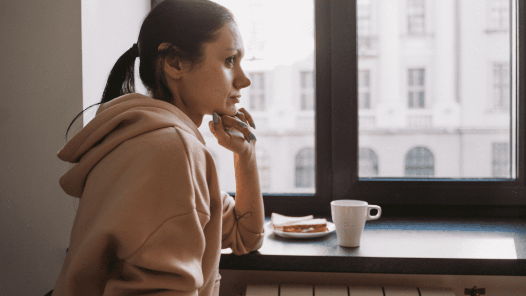Woman with breakfast sitting by a window