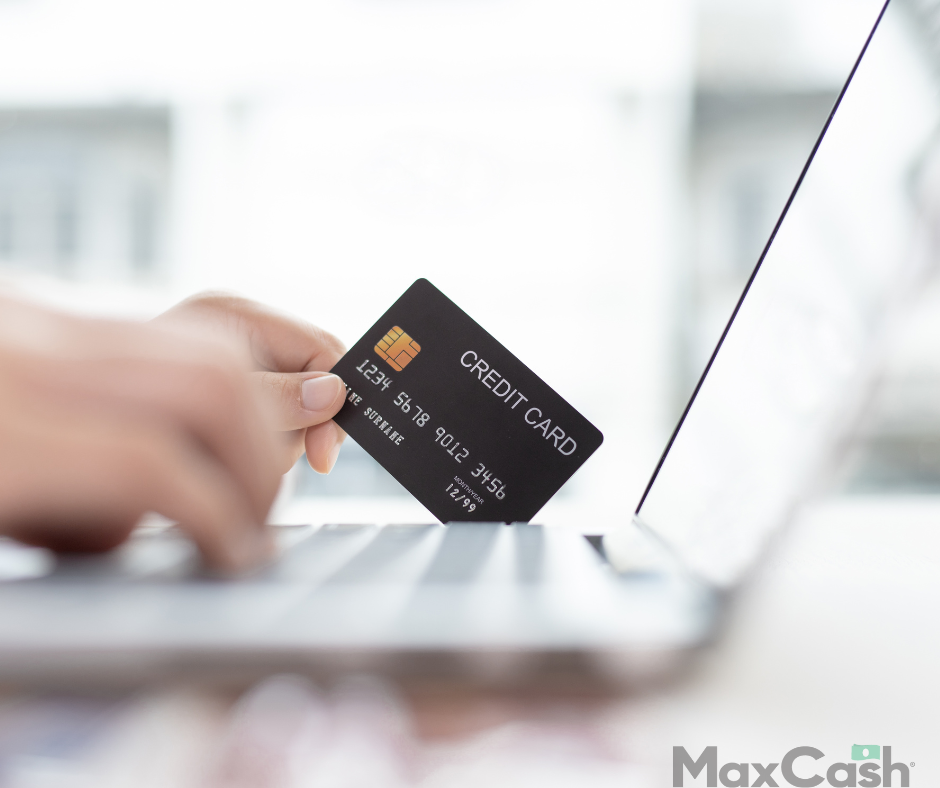 man holding credit card over laptop