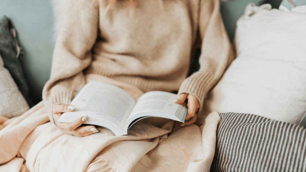 Woman sitting on the bed with a book