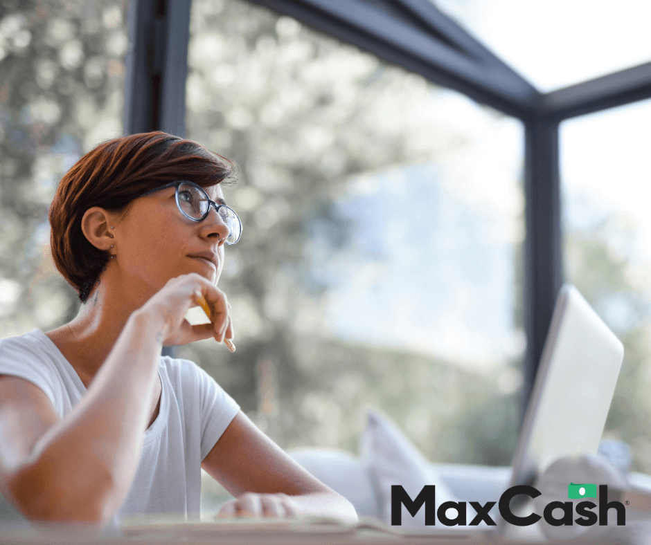 Woman sitting by the computer, thinking with a pencil in her hand