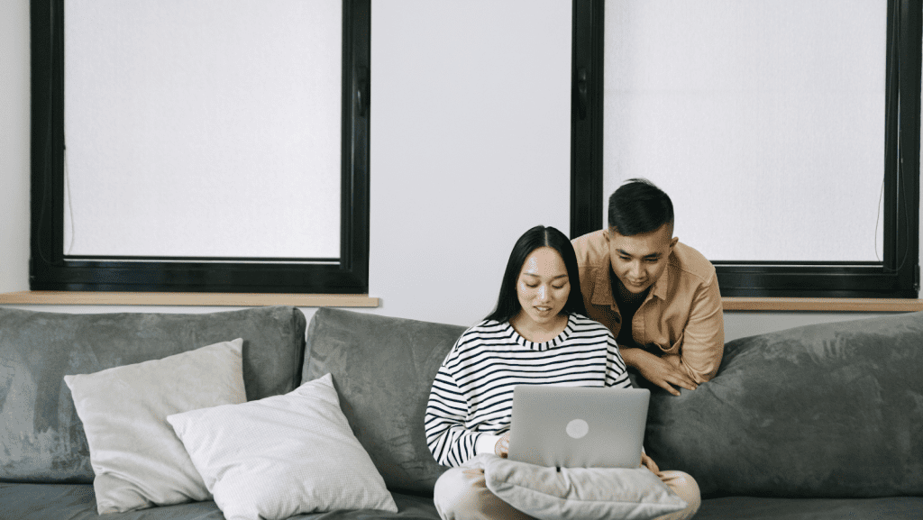 Seated woman on a couch with a computer