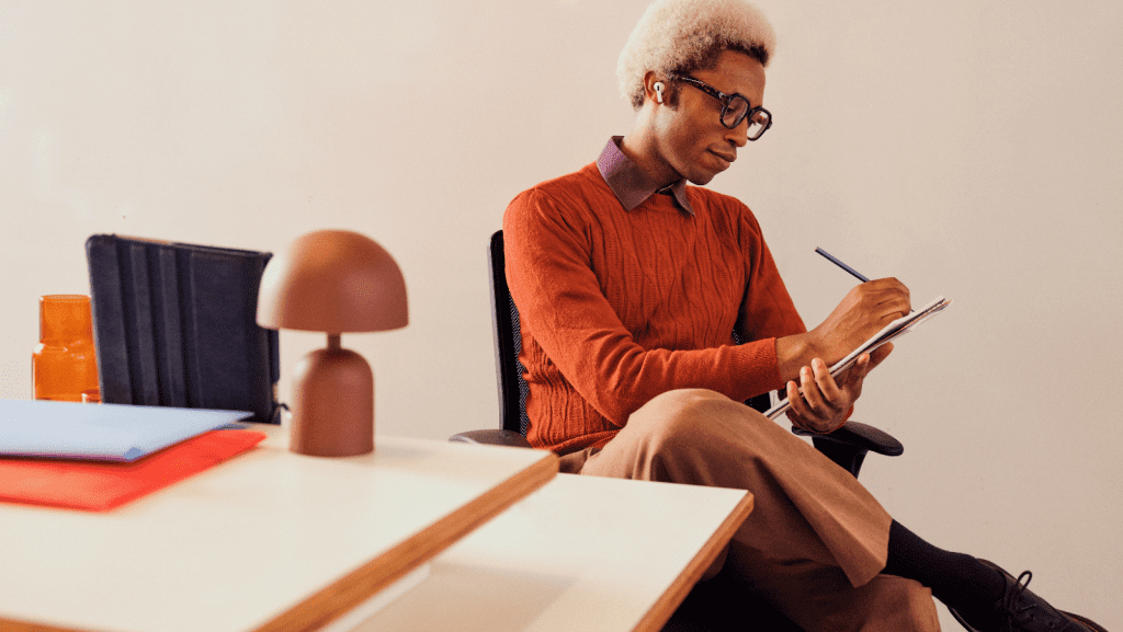 Man holding a notepad and writing down notes