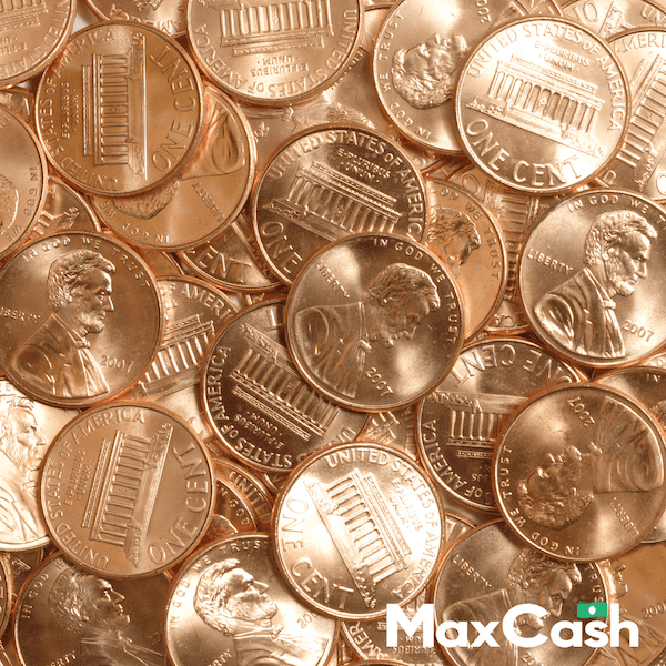 Close-up of scattered US pennies showing Lincoln profile and Capitol building details